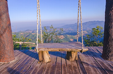 Wooden swing on the mountaintop in sunlight