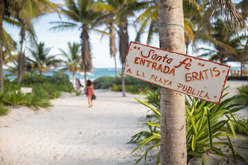 Sign on a palm tree welcoming to the Santa Fe beach