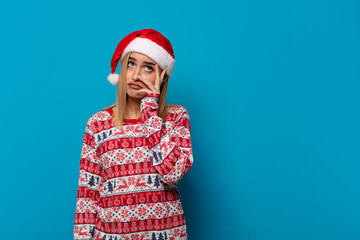 blonde woman with santa hat feeling bored, frustrated and sleepy after a tiresome, dull and tedious...