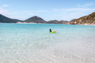 Mulher com boia na praia em Arraial do Cabo no Rio de Janeiro