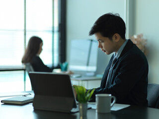 Businessman working with office supplies in modern office room