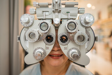 patient checking eyesight value for new eyeglasses with phoropter