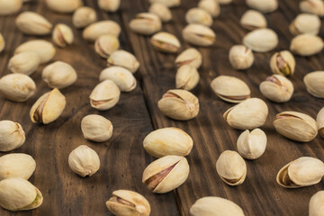 Pistachios scattered on a wooden table. Selective focus.