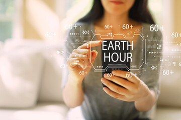 Earth hour with woman using her smartphone in a living room