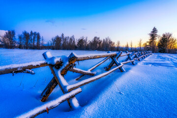 Snow on Split Rail Fence Posts in Snow at Sunrise, sunset 