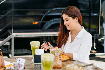 Woman using her phone and eating in a restaurant.