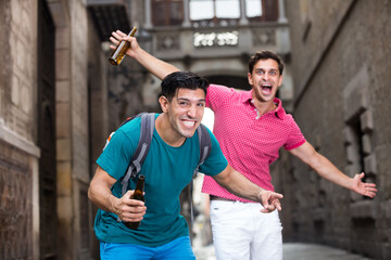 Portrait of two smilling football fans with a beer who are celebrate win of teem in matcn in a...