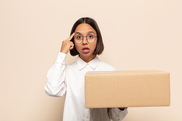 young latin woman looking surprised, open-mouthed, shocked, realizing a new thought, idea or concept