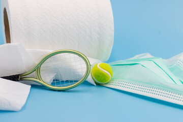 Tennis Covid prevention with face mask, hand sanitizer, tissue paper on blue background