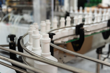 Plastic bottles on the automated conveyor line on the chemical factory. Cleaners production. Shallow depth of field.