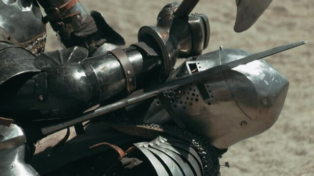 Close up shot of knight killing opponent after fight. Beautiful sunny day on medieval war festival. Slow motion footage.
