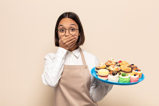 young latin woman covering mouth with hands with a shocked, surprised expression, keeping a secret or saying oops