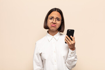 young latin woman feeling sad and whiney with an unhappy look, crying with a negative and...