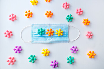 development of the game in the period of the pandemic. Health and recreation concept of family safety in the context of the covid-19 coronavirus pandemic. the medical mask on the multi-colored toys