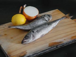 Two raw mackerels on a wooden board