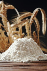 Pile of flour at wheat ears background
