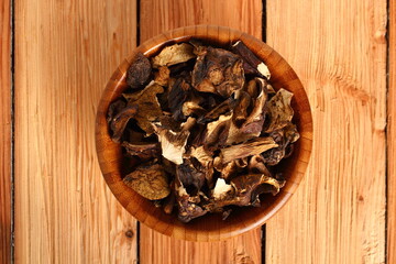 Dried mushrooms in wooden bowl. Boletus badius.