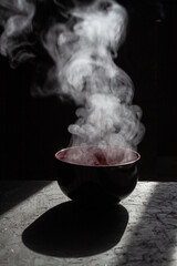 Bowl of soup. steam of hot soup with smoke wood bowl on dark background.selective focus,hot food...