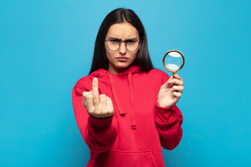 young latin woman feeling angry, annoyed, rebellious and aggressive, flipping the middle finger,...