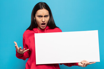 young latin woman looking angry, annoyed and frustrated screaming wtf or what’s wrong with you