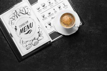 Cup of hot coffee and menu on table in cafe