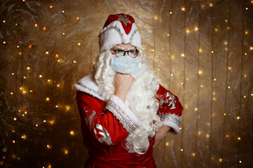 Santa Claus in glasses and a mask against a virus shows a hand gesture