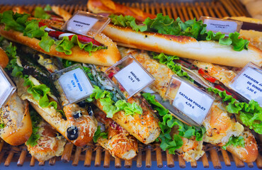 Image of tasty French sandwiches with cheese, tomato and olives on the counter