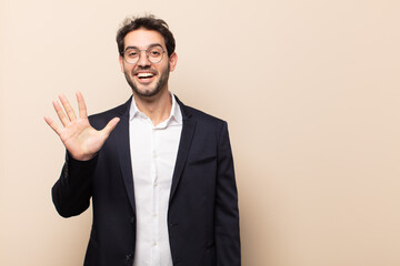 young handsome man smiling and looking friendly, showing number five or fifth with hand forward,...