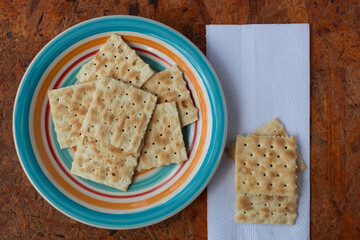 Some soda crackers, a plate and a napkin.
