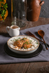Meatballs with rice on rustic background