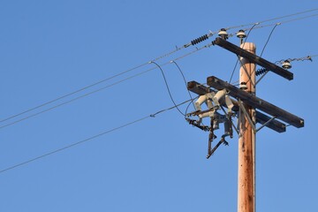 Power line with glass insulators and wires. One power pole off center, room for copy.  Blue sky in...