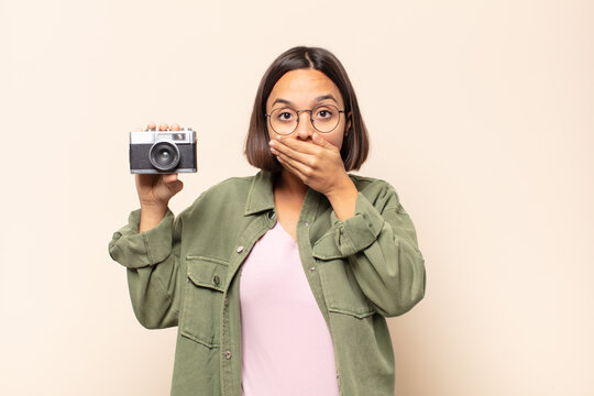 young latin woman covering mouth with hands with a shocked, surprised expression, keeping a secret or saying oops