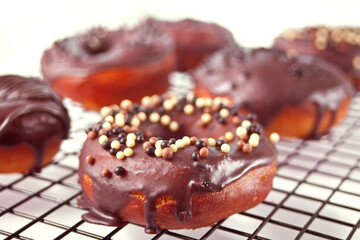 Doughnut on the baking rack glazed with chocolate cream or icing. Breakfast concept.