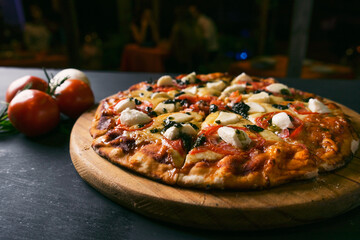 top view Traditional italian pizza with green basil pesto sauce on a black rustic wooden background. restaurant blur background