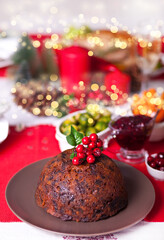Fototapeta na wymiar Traditional Christmas pudding with holly on top on a Christmas dinner.