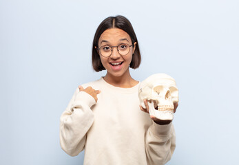 young latin woman feeling happy, surprised and proud, pointing to self with an excited, amazed look