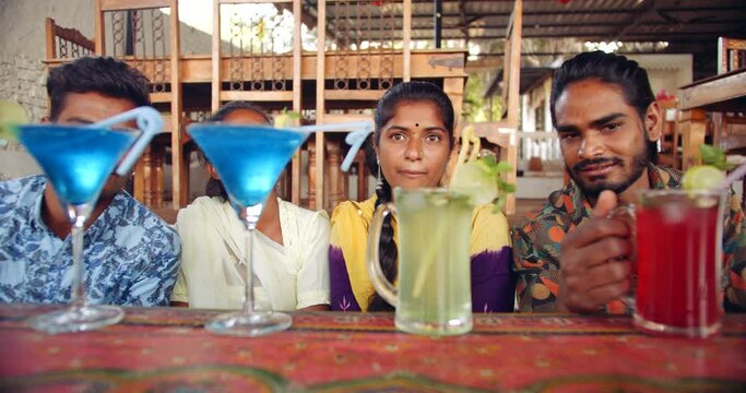 Two women and two men looking staring leeching at cocktail tasy delicious mocktail drinks liquid alchol times to party enjoy have fun joyous smile while wearing masks 