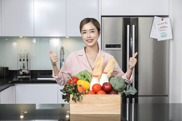 Grocery store smart food delivery serviceman in red uniform handing fresh food to the recipient and young woman customer receiving an order from courier at home, express delivery, food delivery.