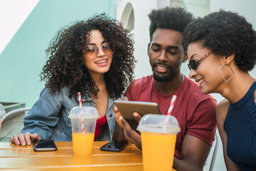 Three afro friends using digital tablet.