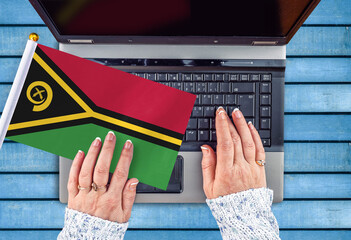 woman hands and flag of Vanuatu on computer, laptop keyboard 