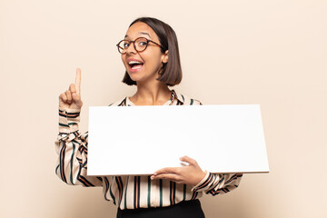 young latin woman feeling like a happy and excited genius after realizing an idea, cheerfully...