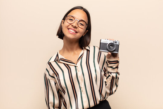 young latin woman smiling happily with a hand on hip and confident, positive, proud and friendly attitude