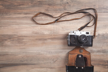Old retro camera on wooden background.