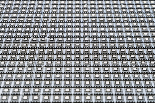 LED matrix outdoor screen close-up. Straight rows of LEDs on a modular panel. Limited depth of field.