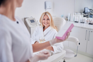 Pretty lady in white clothes looking to her doctor in cabinet