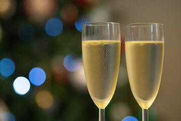 Champagne glasses over holiday bokeh blinking background, rotating on turntable, glasses with sparkling wine, celebration, party. High quality 4k footage