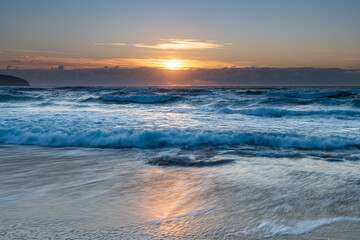 Fototapeta na wymiar Sunrise seascape with light cloud, waves and rocks