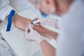 Professional nurse getting treatment drip for patient in beauty clinic