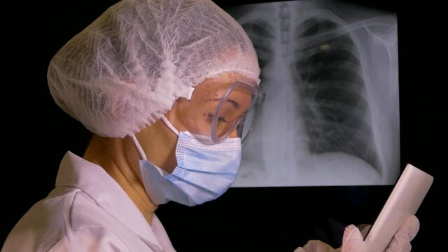 The doctor looks at the x-ray of the lungs. Pneumonia diagnosis. Consultation of doctors on covid 19. Patient examination