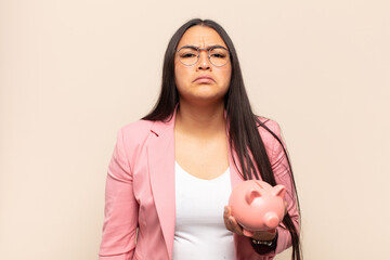 young latin woman feeling sad and whiney with an unhappy look, crying with a negative and...